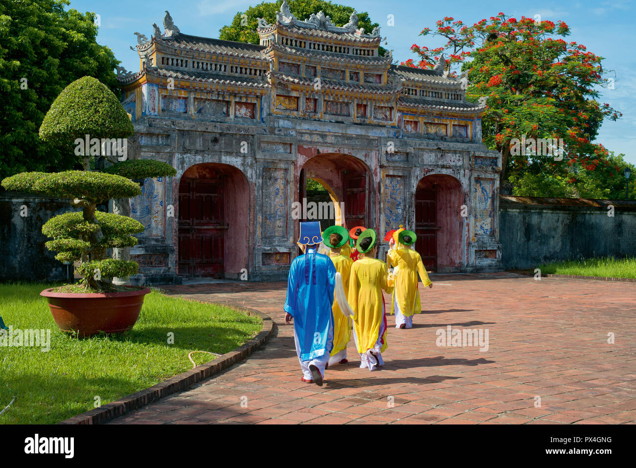 Vietnamese extras walk through West Gate, Chuong Duc, Imperial Palace Hoang Thanh, Hue, Vietnam Stock Photo