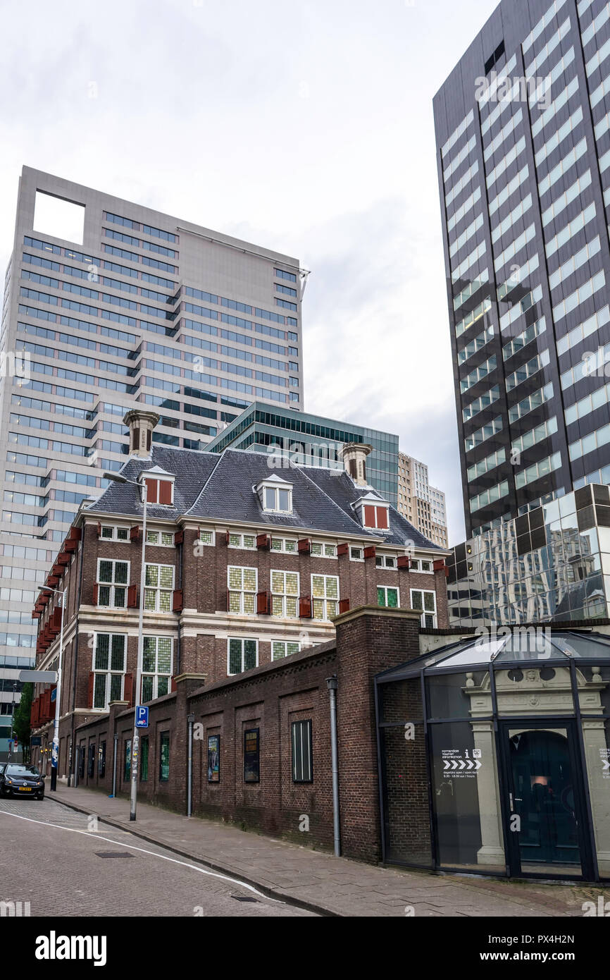 Old-fashioned low building among towering glass skyscrapers. Old and new, aged and modern. Stock Photo