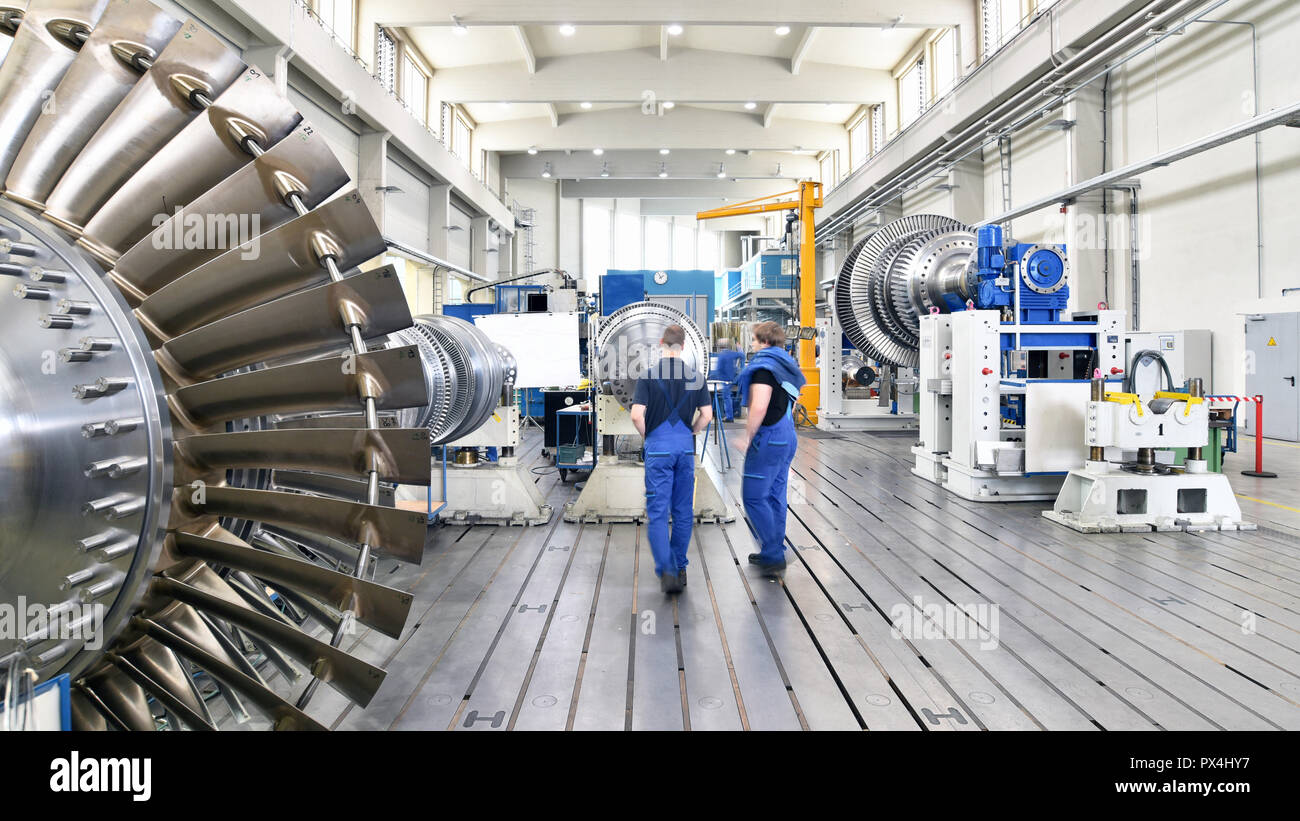 workers assembling and constructing gas turbines in a modern industrial factory Stock Photo