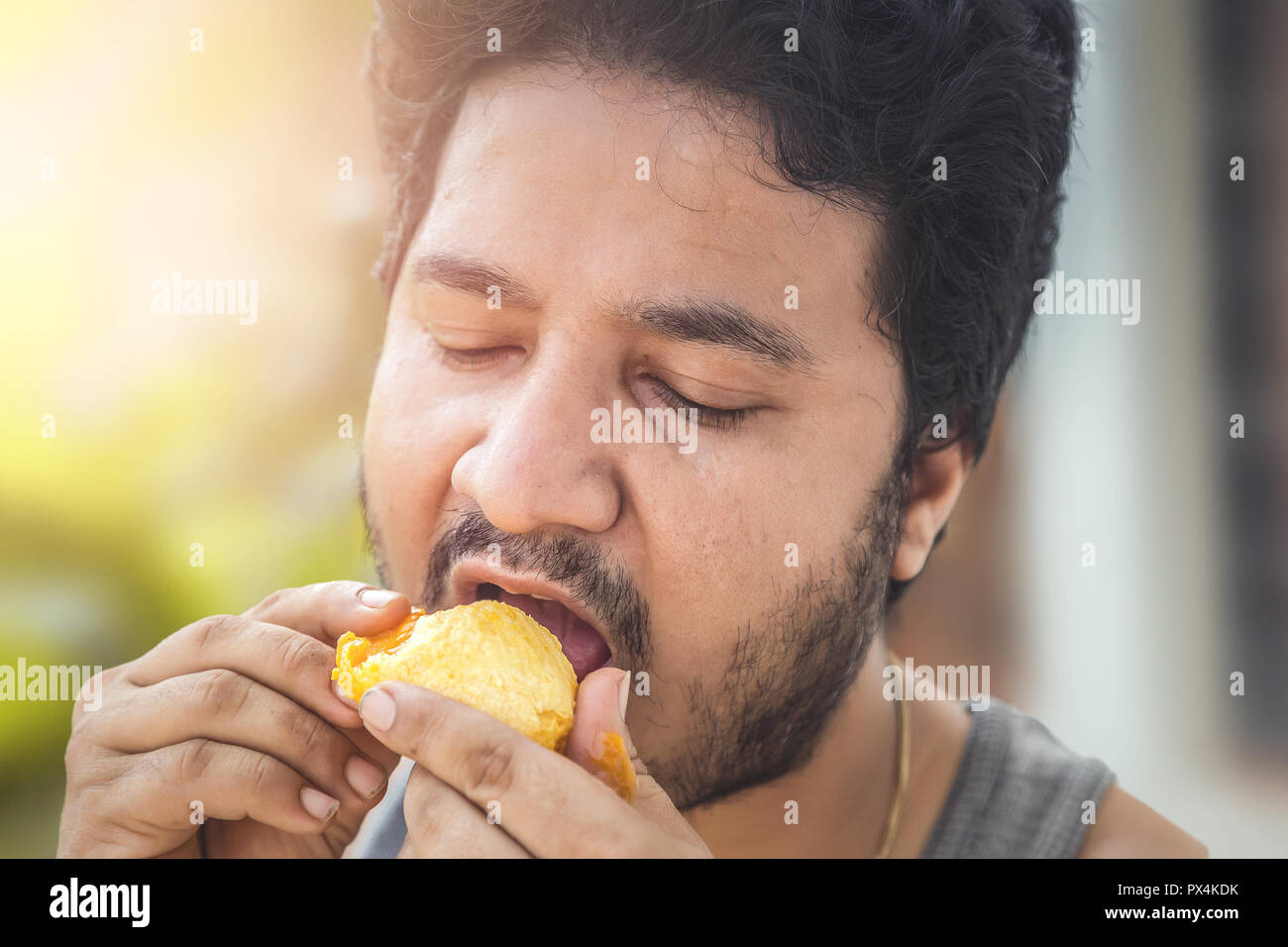 Indian man eating mango Stock Photo Alamy