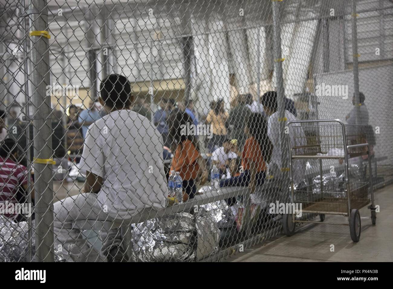 Alleged illegal border crossers behind the fence at the Central Processing Center in McAllen, Texas, June 17, 2018. Image courtesy United States Department of Defense. () Stock Photo