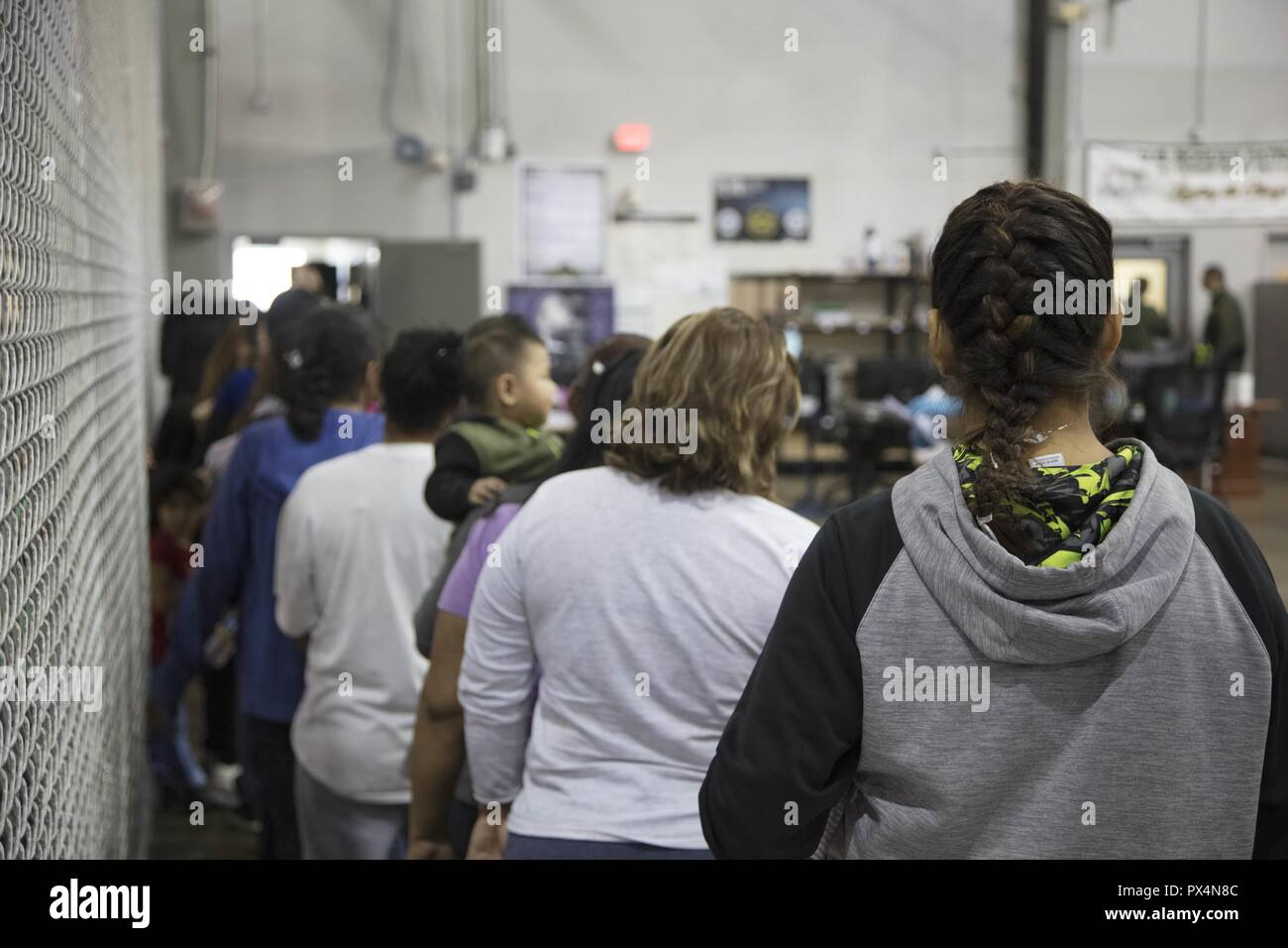 Alleged illegal border crossers waiting in line at the Central Processing Center in McAllen, Texas, June 17, 2018. Image courtesy United States Department of Defense. () Stock Photo