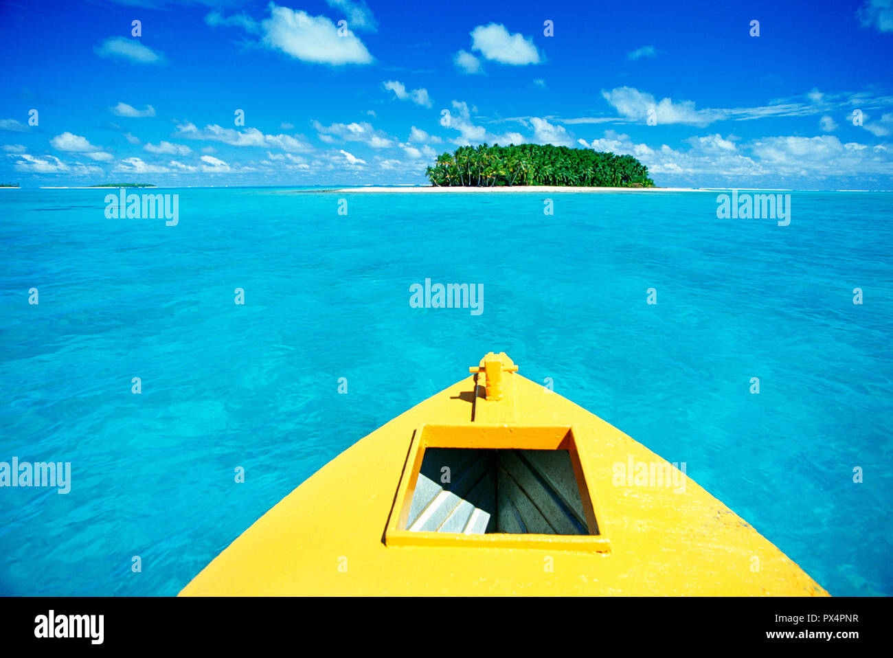 View over boat bow toward small tropical island in Aitutaki Lagoon, Cook Islands, South Pacific Ocean. Stock Photo