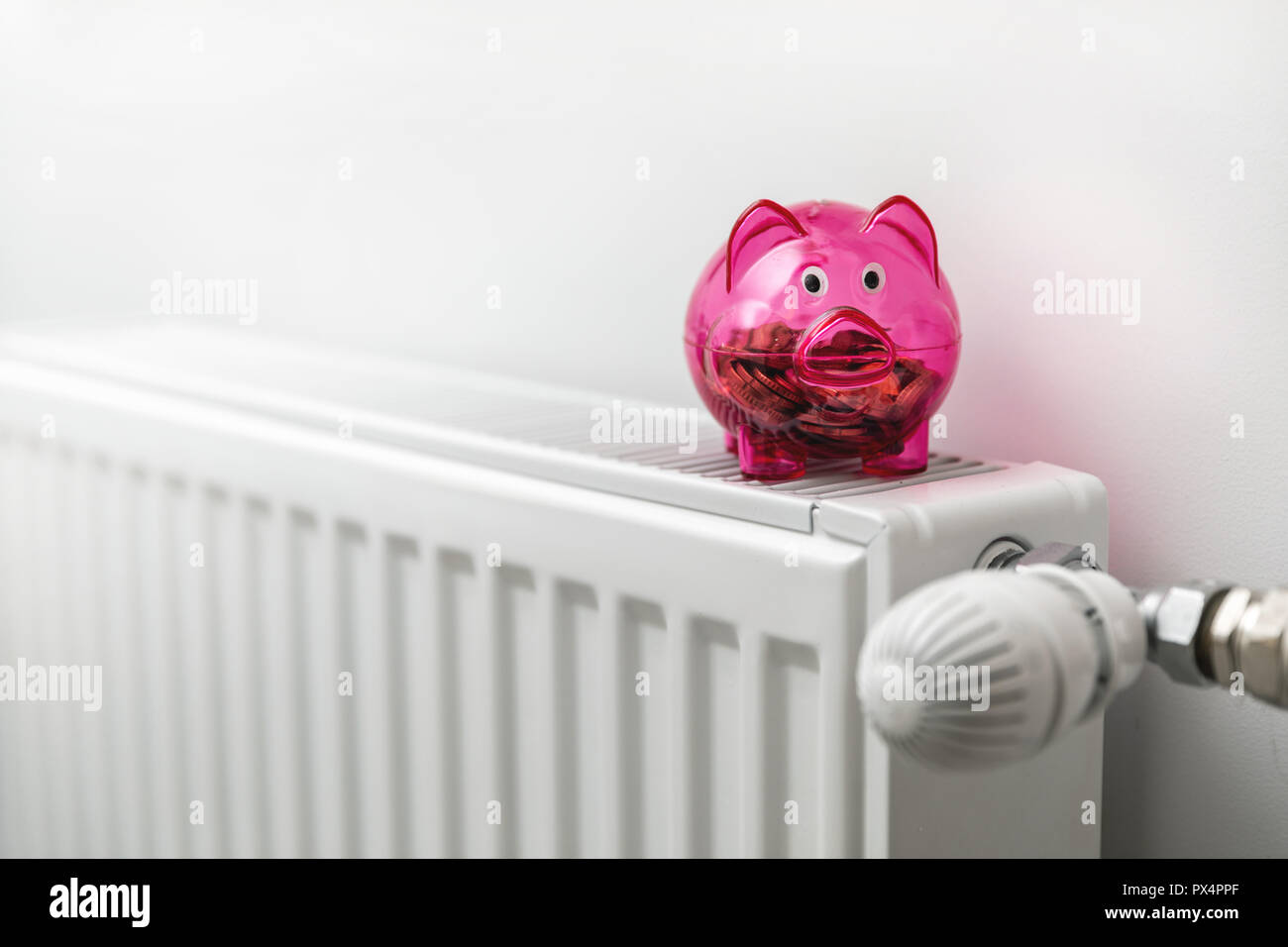 energy efficiency house - piggy bank on the radiator Stock Photo