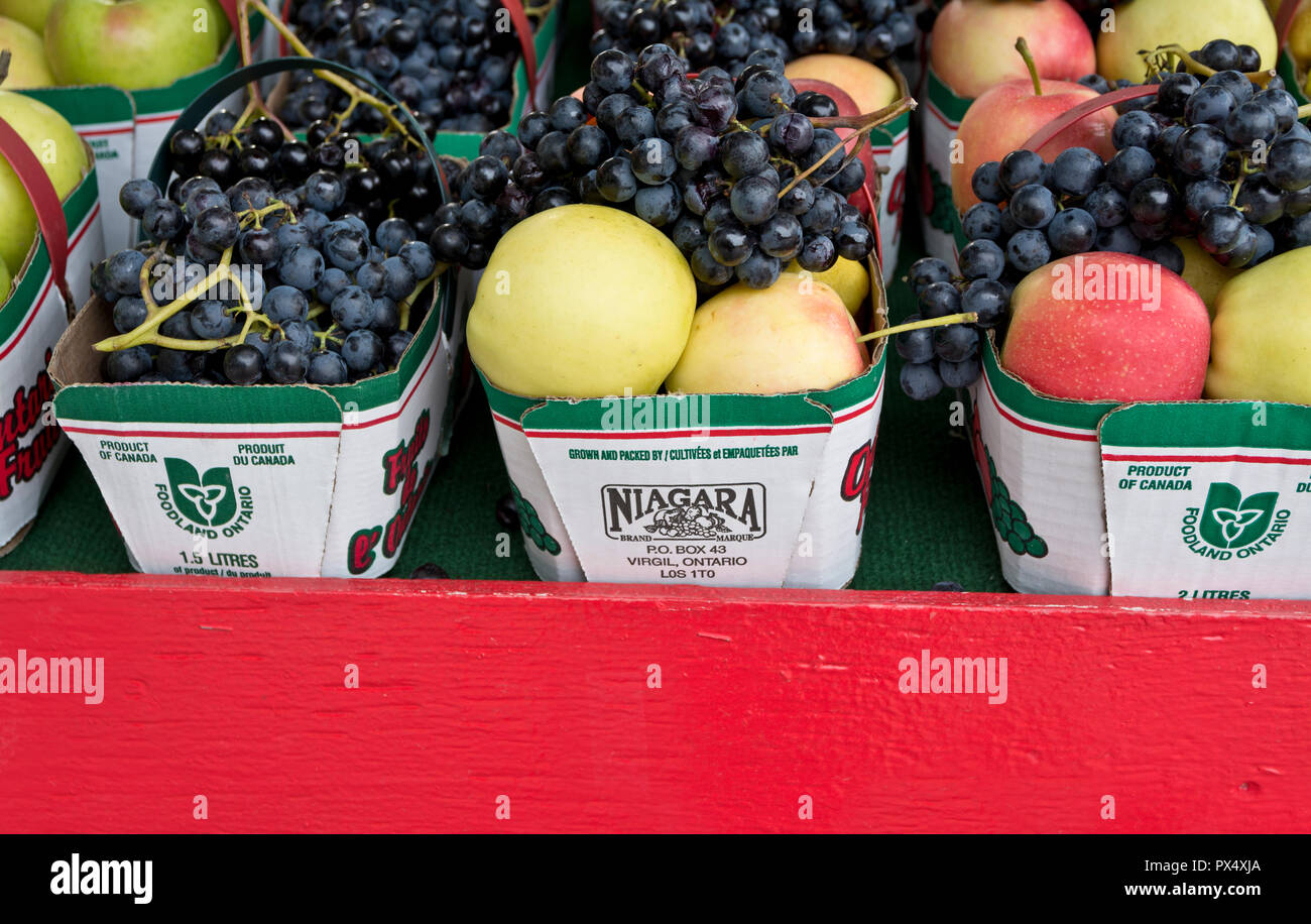 Baskets of apples and grapes for sale at a local farm stand in the