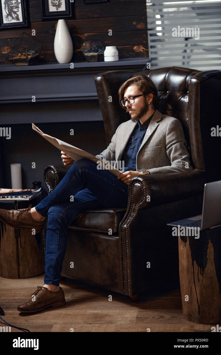 Young man reading a newspaper Stock Photo - Alamy