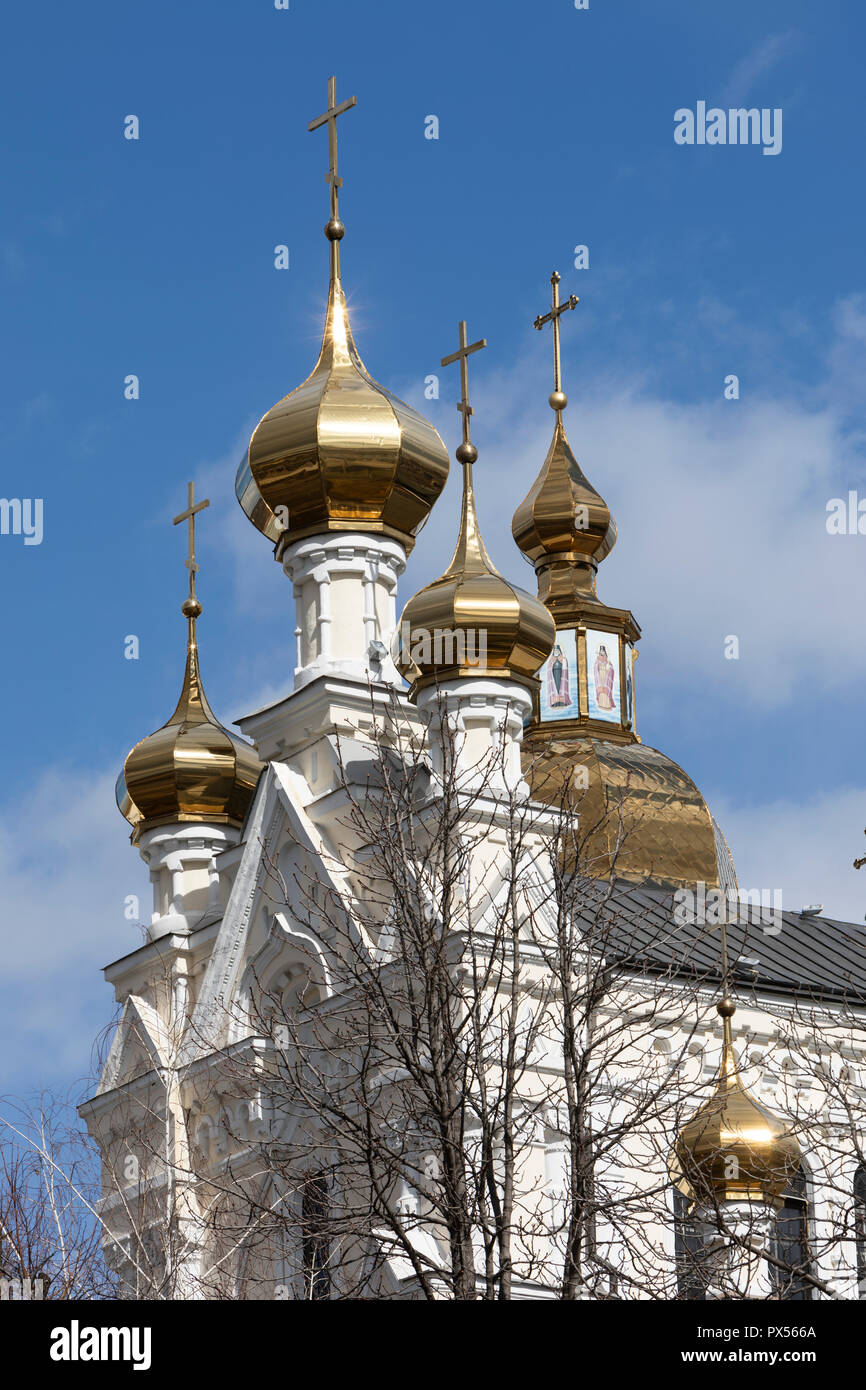 A part of a church with gold domes with a blue sky and white clouds in ...