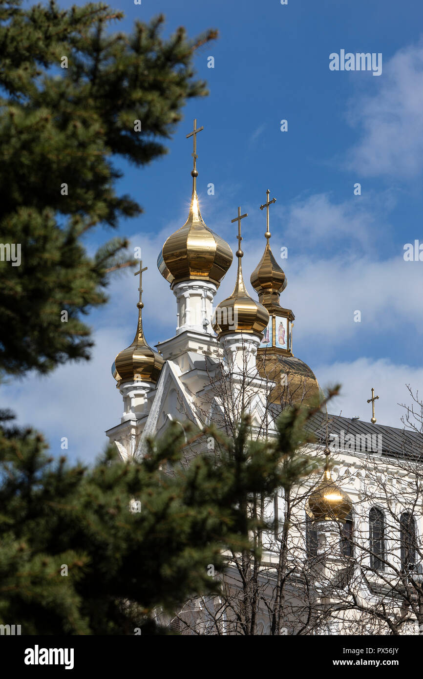 A part of a church with gold domes with a blue sky and white clouds in ...