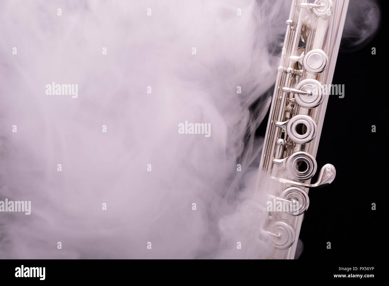A silver plated flute in smoke on a black background Stock Photo - Alamy