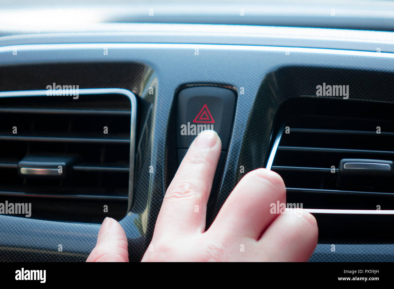 woman pushes a button in the car Stock Photo