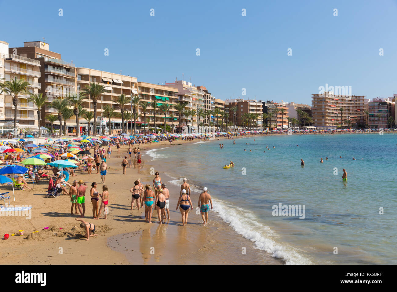 Spanish sunshine Torrevieja beach in October with people enjoying the sea sand and weather Stock Photo
