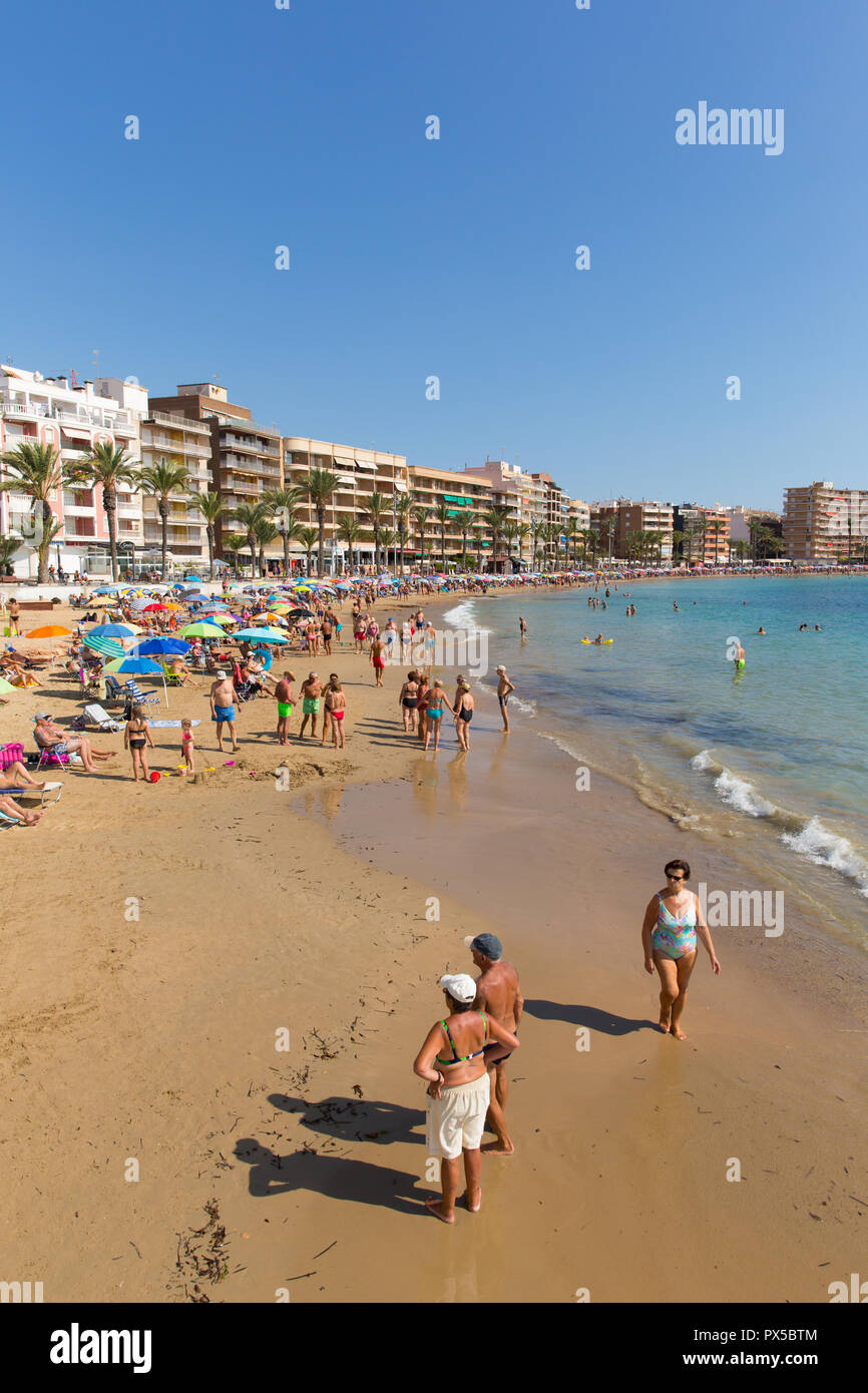 Spanish sunshine Torrevieja beach in October with people enjoying the sea sand and weather Stock Photo