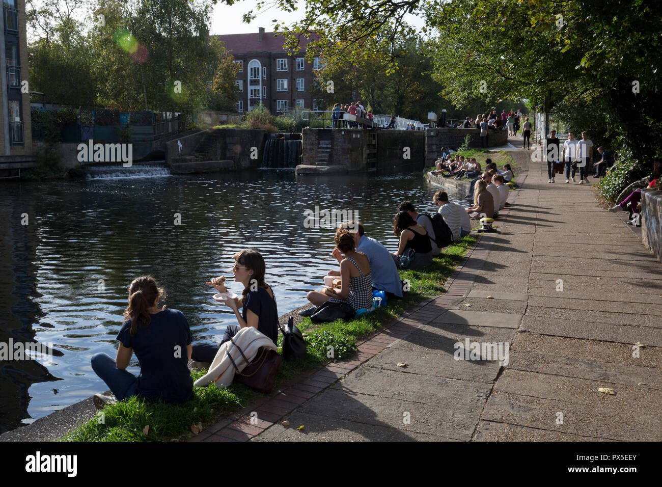 Londoners enjoy an autumnal Indian Summer on the Regent's Canal towpath in Hackney, on 16th October 2018, in London, England. Stock Photo