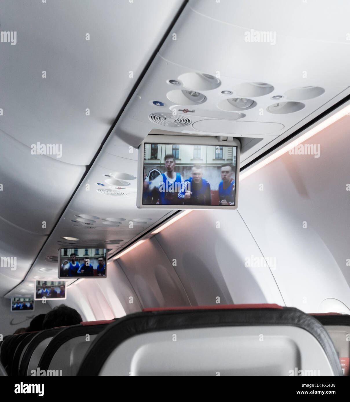 Drop down video screens on low cost Norwegian airlines flight. Stock Photo