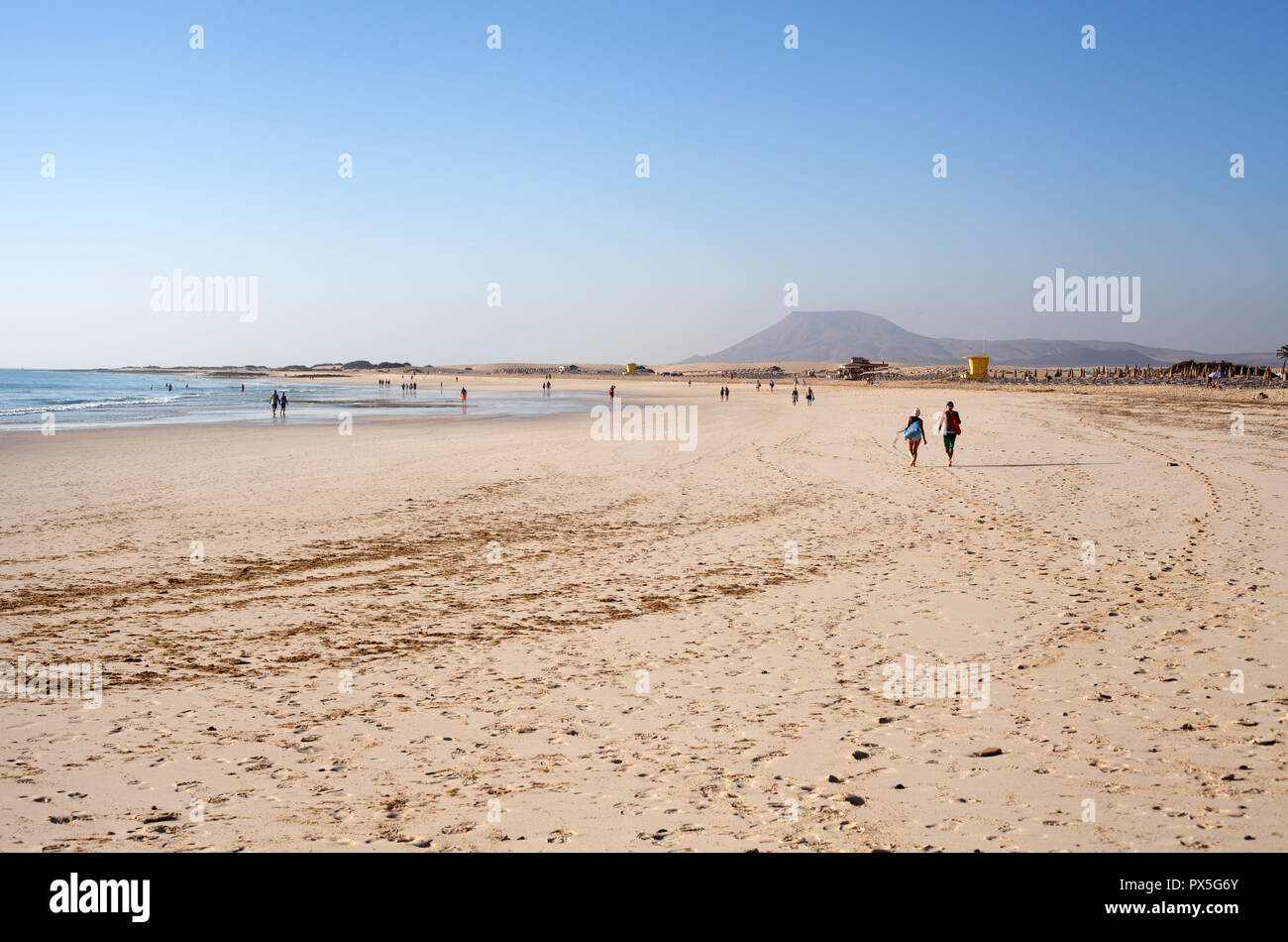 People enjoying a morning walk on an empty beach Las Playas Grandes at low  tide, Corralejo, Fuerteventura,Canary Islands Stock Photo - Alamy