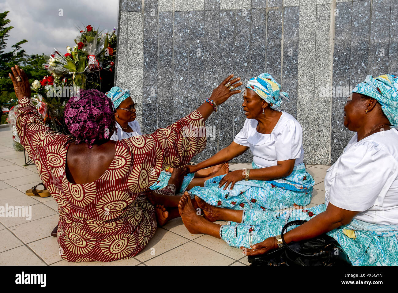 Pilgrims praying and joining hands at Our Lady of Africa catholic sanctuary, Abidjan, Ivory Coast. Stock Photo