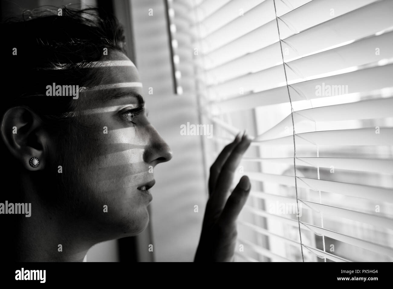A Depressed young woman near window at home, closeup Stock Photo