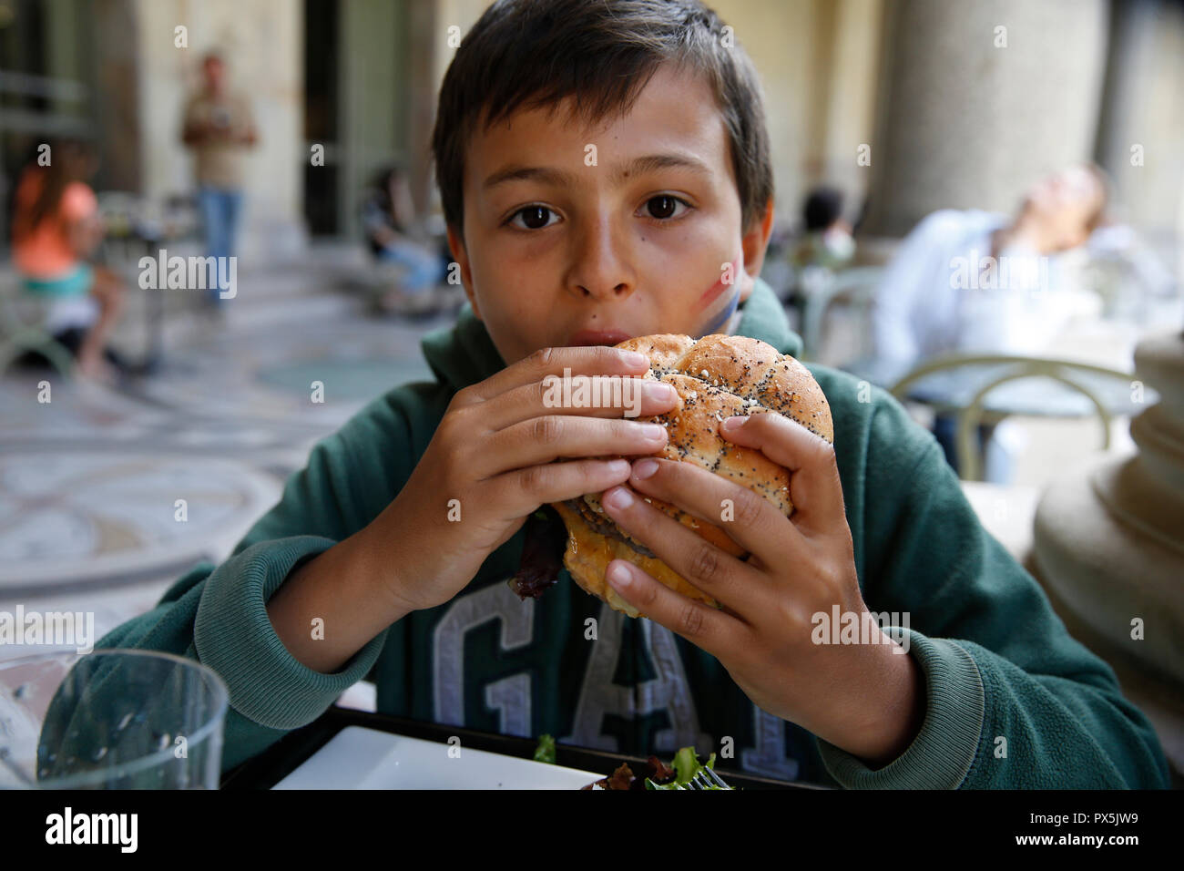 11yearold boy eating a hamburger in Paris, France Stock Photo Alamy