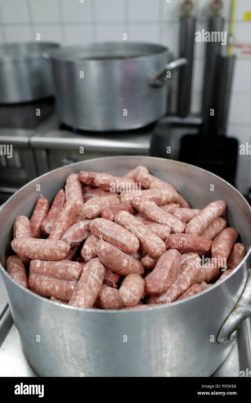Cooking diots in a kitchen. A diot is a sausage from the French region of Savoy.  France. Stock Photo