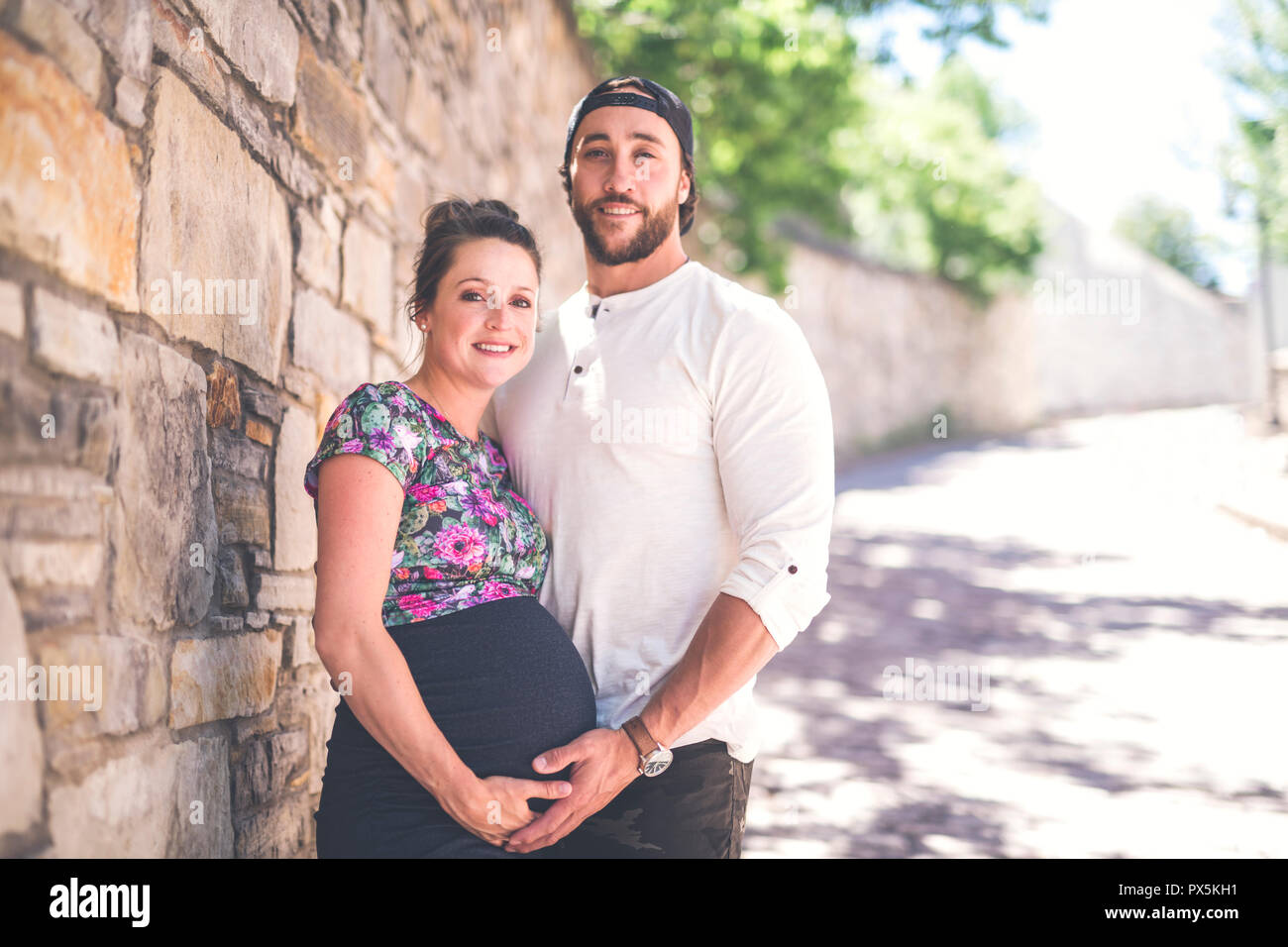 A Pregnant couple portrait outside in the neighborhood Stock Photo