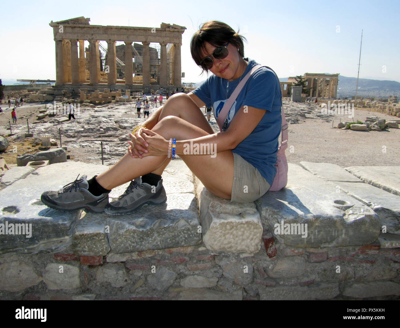 A young girl sits on the back  Parthenon on the Acropolis, Athens,  and takes a selfie photo for memory .Day Stock Photo