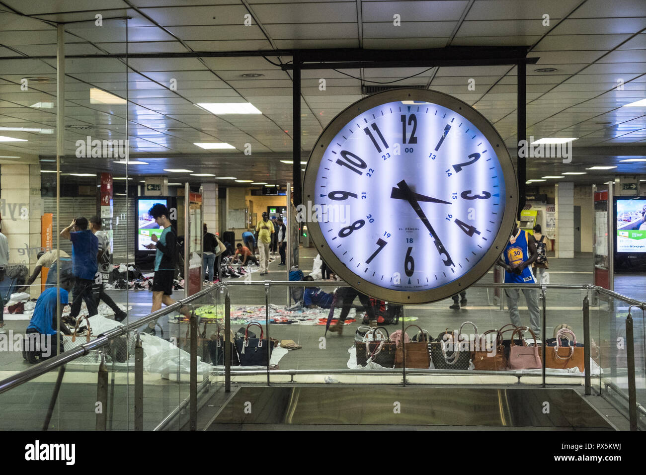 Huge,clock,at,Placa de Catalunya,train,metro,station,with,blanket,men,selling,Barcelona,Catalan,Catalonia,Catalunya,Spain,Spanish,Europe,European, Stock Photo