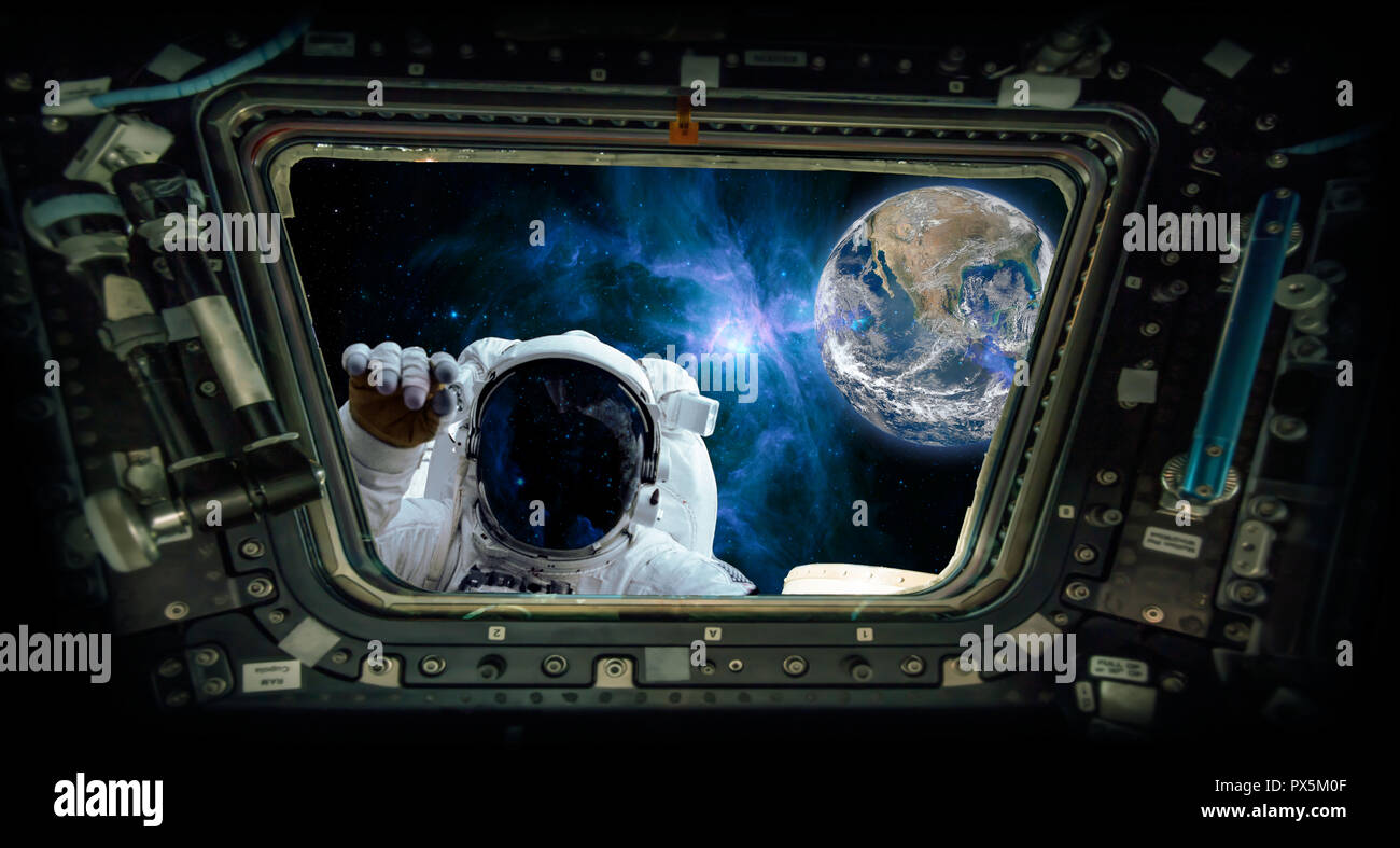 View from a spaceship window with an astronaut knocking and the earth 'Elements of this image furnished by NASA' Stock Photo
