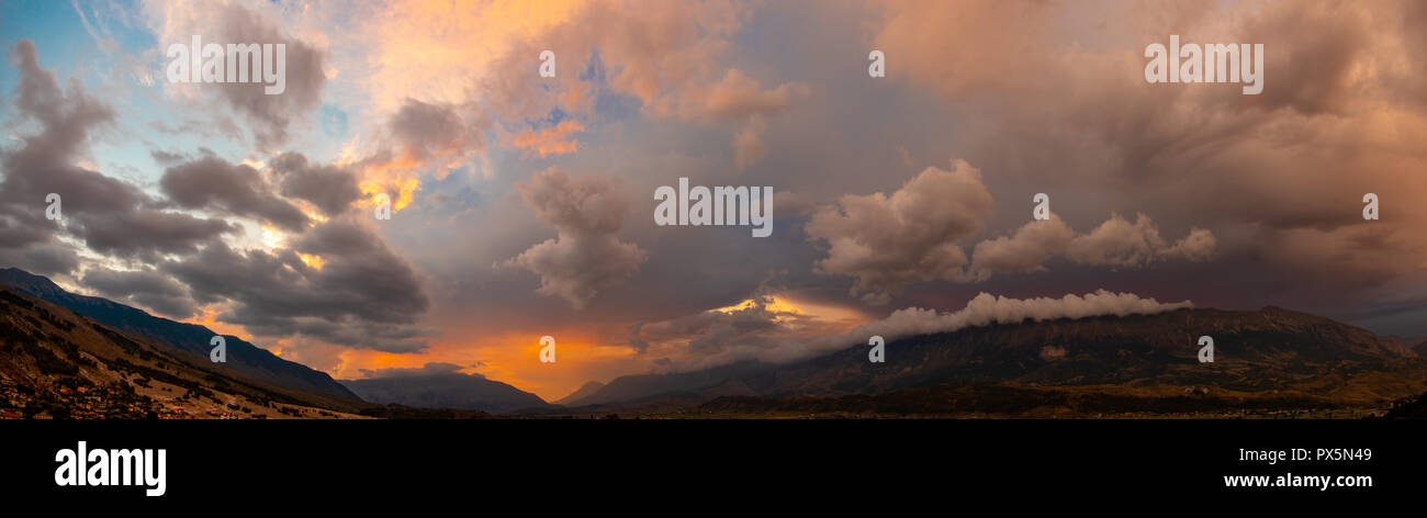 dramatic panorama sky with thunderclouds and mountains at sunset Stock Photo