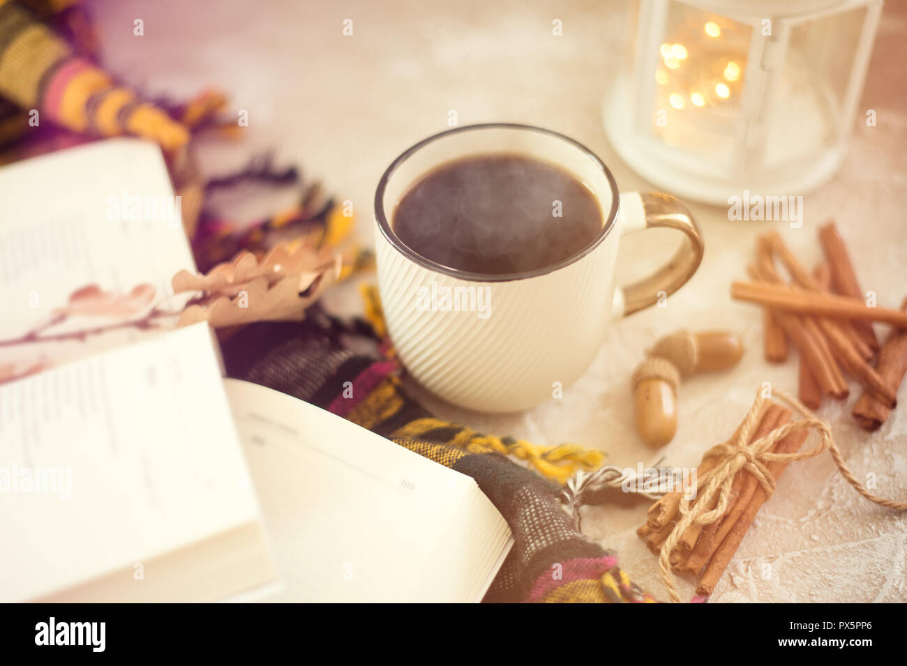 Autumn composition. Cup of coffee, blanket, autumn leaves, cinnamon sticks on beige background Stock Photo