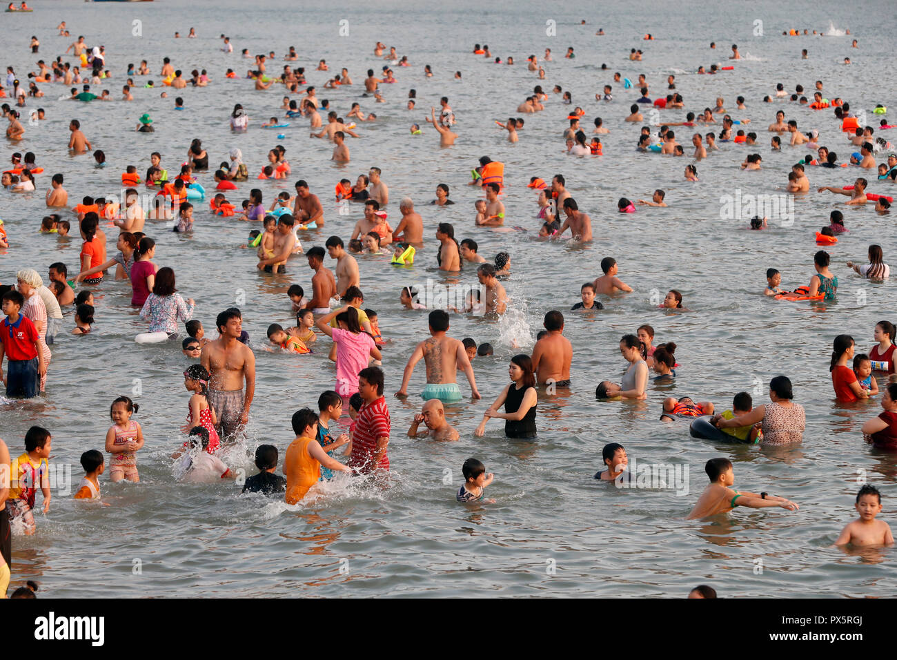 Sunday at the beach. Vietnamese families swiming in the south China Sea. Hang Dua Bay. Vung Tau. Vietnam. Stock Photo
