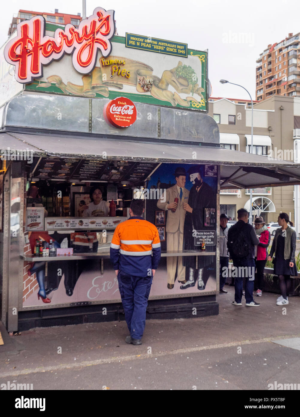 Workmen and tourists buying food from the iconic Harry's Cafe de Wheels   food van on Cowper Wharf Road Sydney NSW Australia. Stock Photo