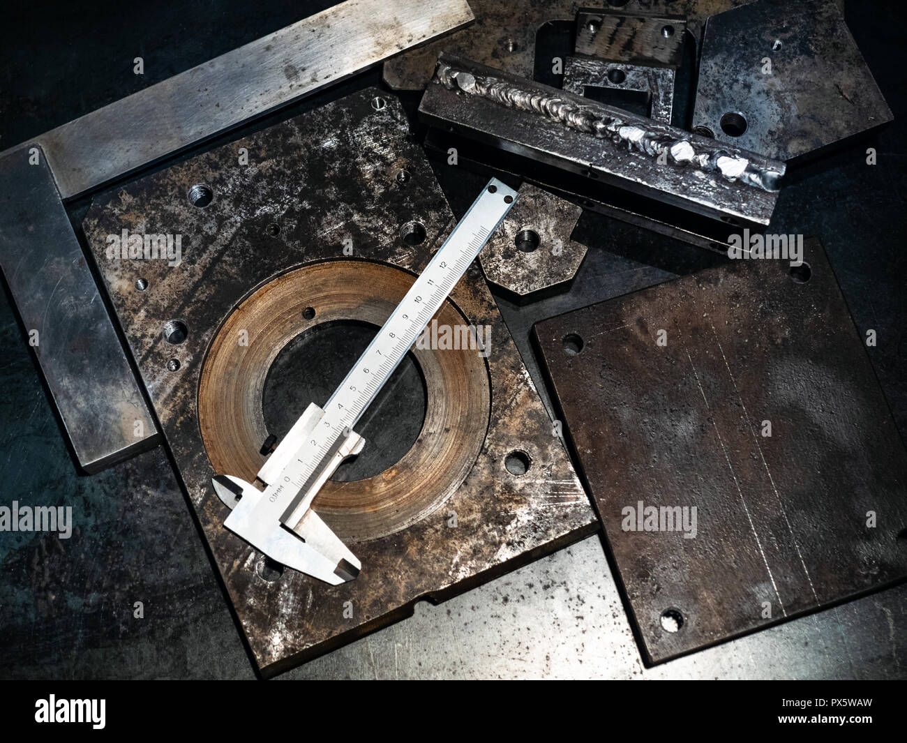 Metalworking still life - top view of calipers on metal workbench in turnery workshop in cold blue light Stock Photo