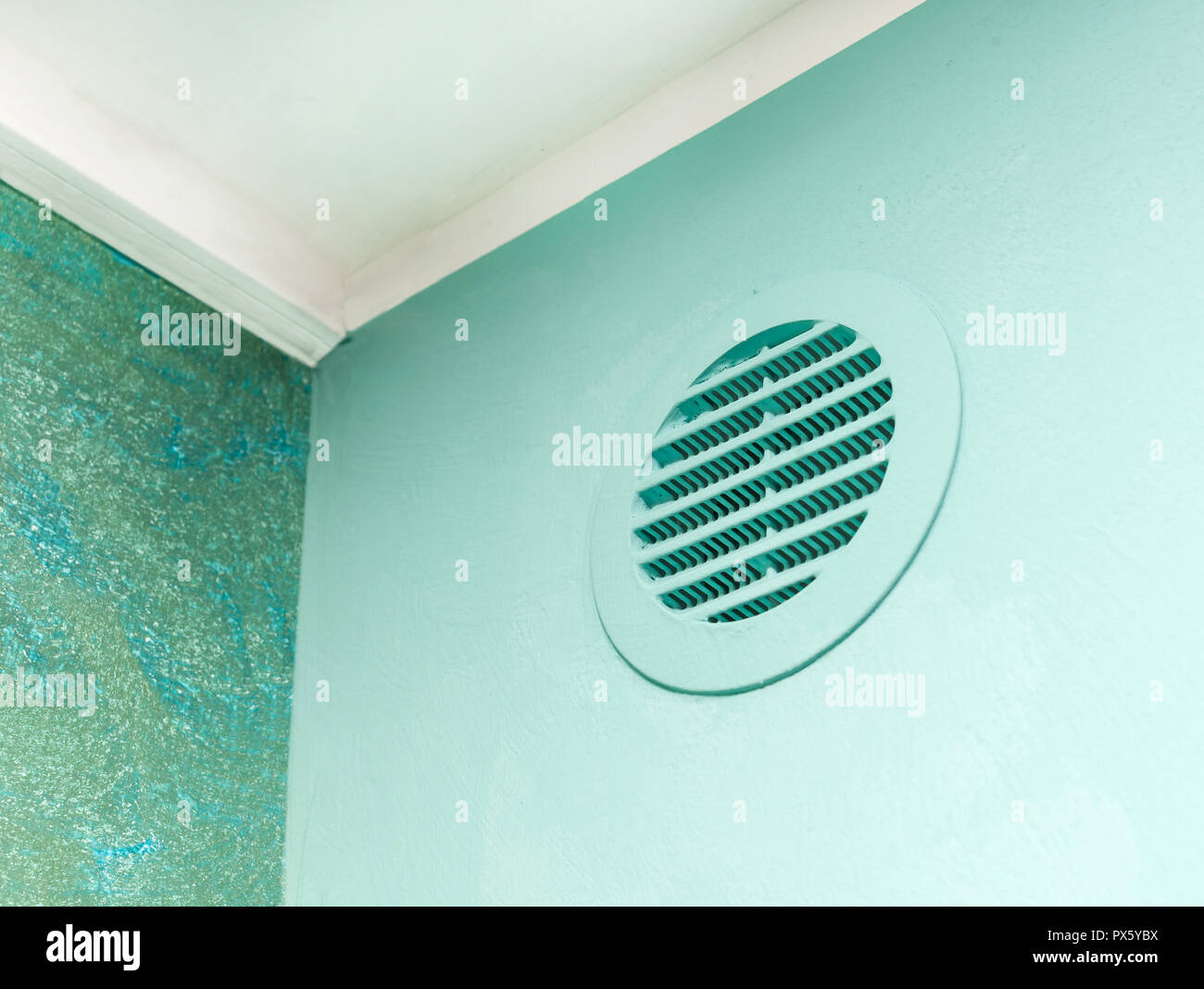 Circle vent window on green wall. Aeration system for plasterboard cavity. Stock Photo