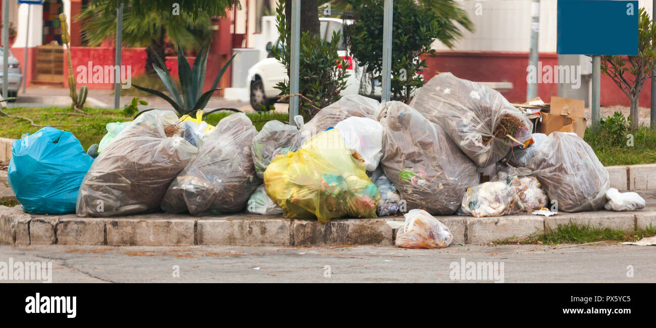 Waste bags in the street on the sidewalks. Stock Photo