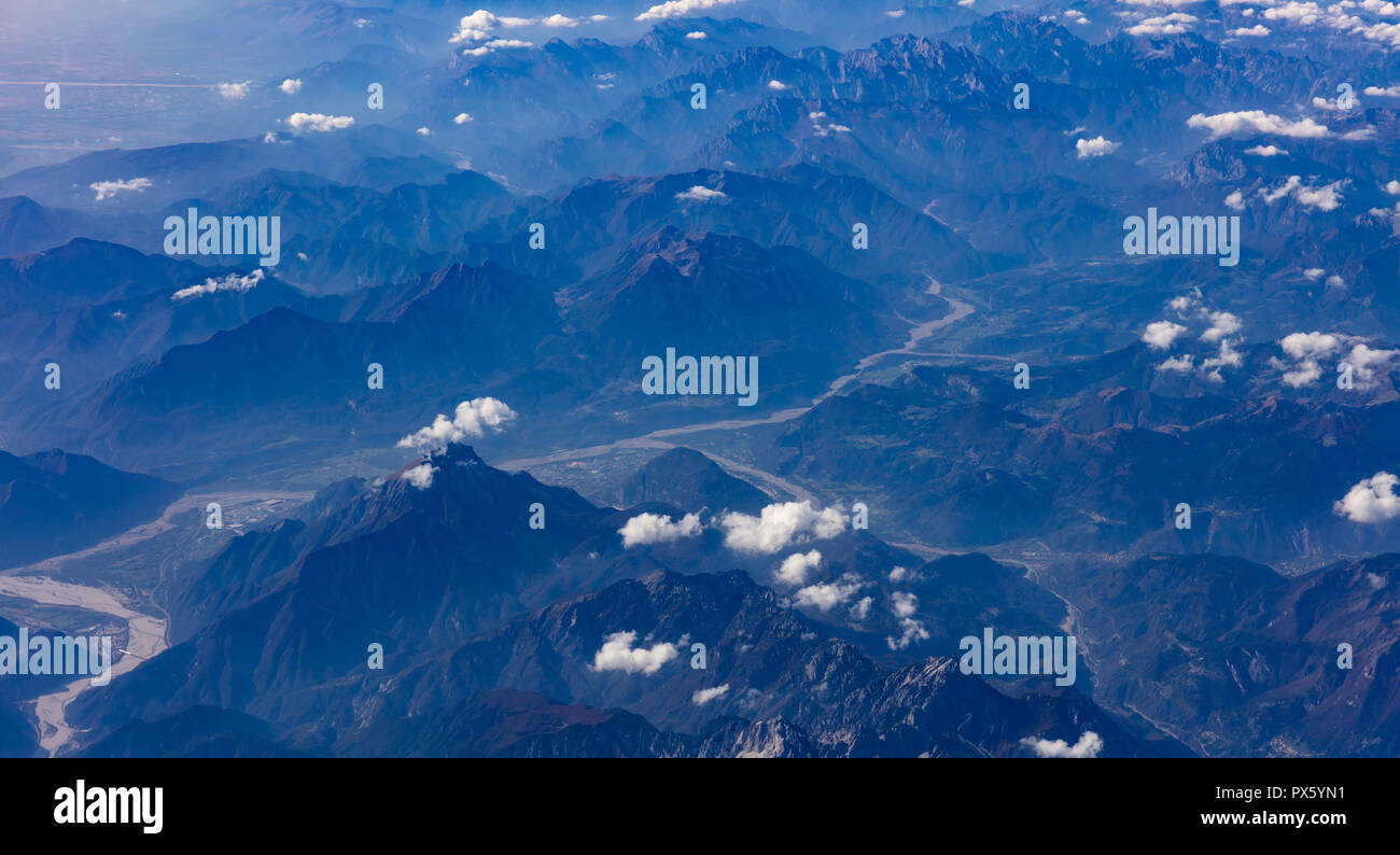 Mountains and blue sky with clouds. Aerial view out of a plane window ...
