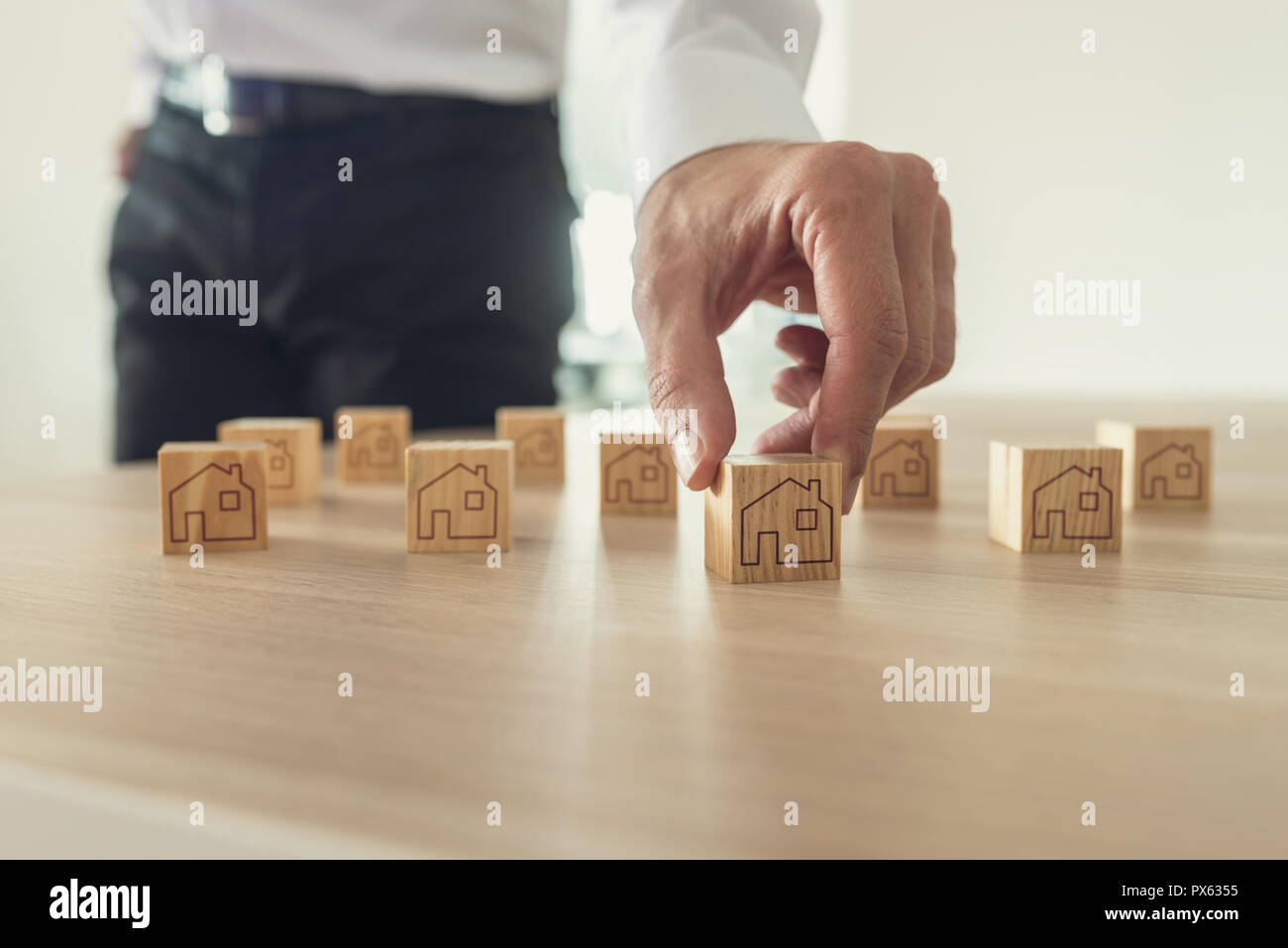 Retro image of businessman arranging wooden blocks with house icon on ...
