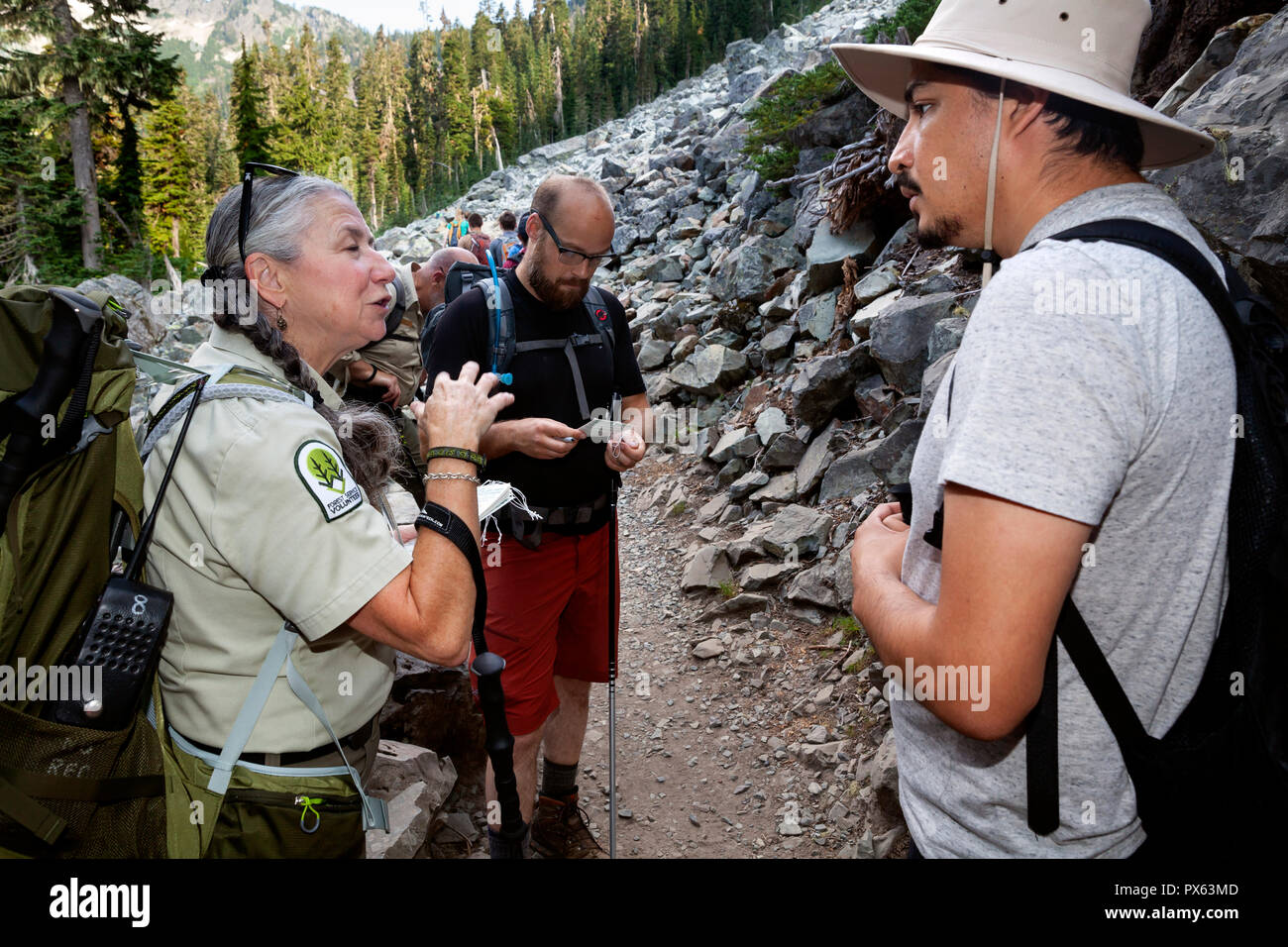 WA14849-00...WASHINGTON - Forest Service Volunteer Jane-Ellen talkes with hikers about filling out a wilderness permit on the Snow Lakes Trail in the  Stock Photo