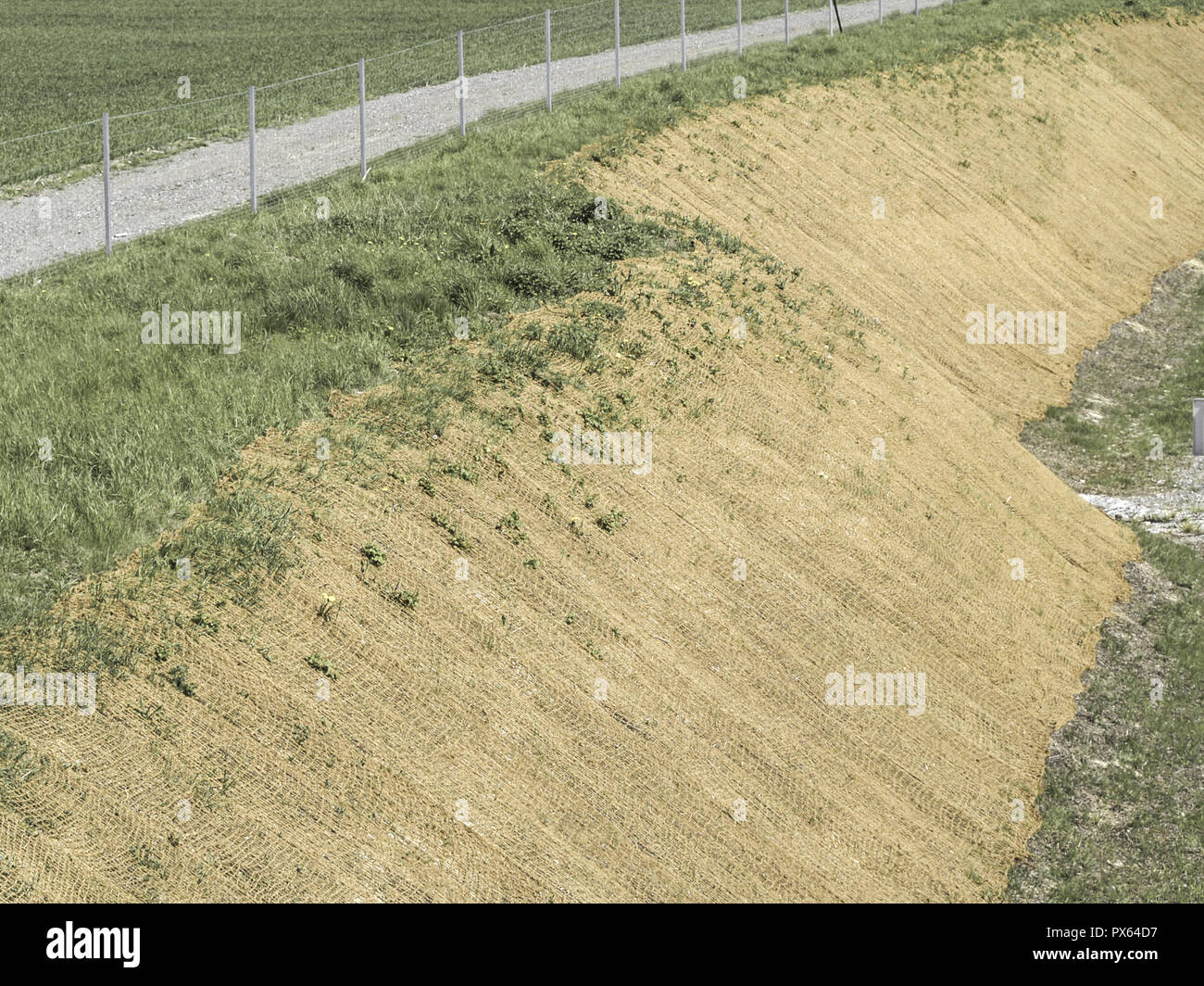 Slope with brown earth and gravel walk, slope fixing with jute net Stock  Photo - Alamy