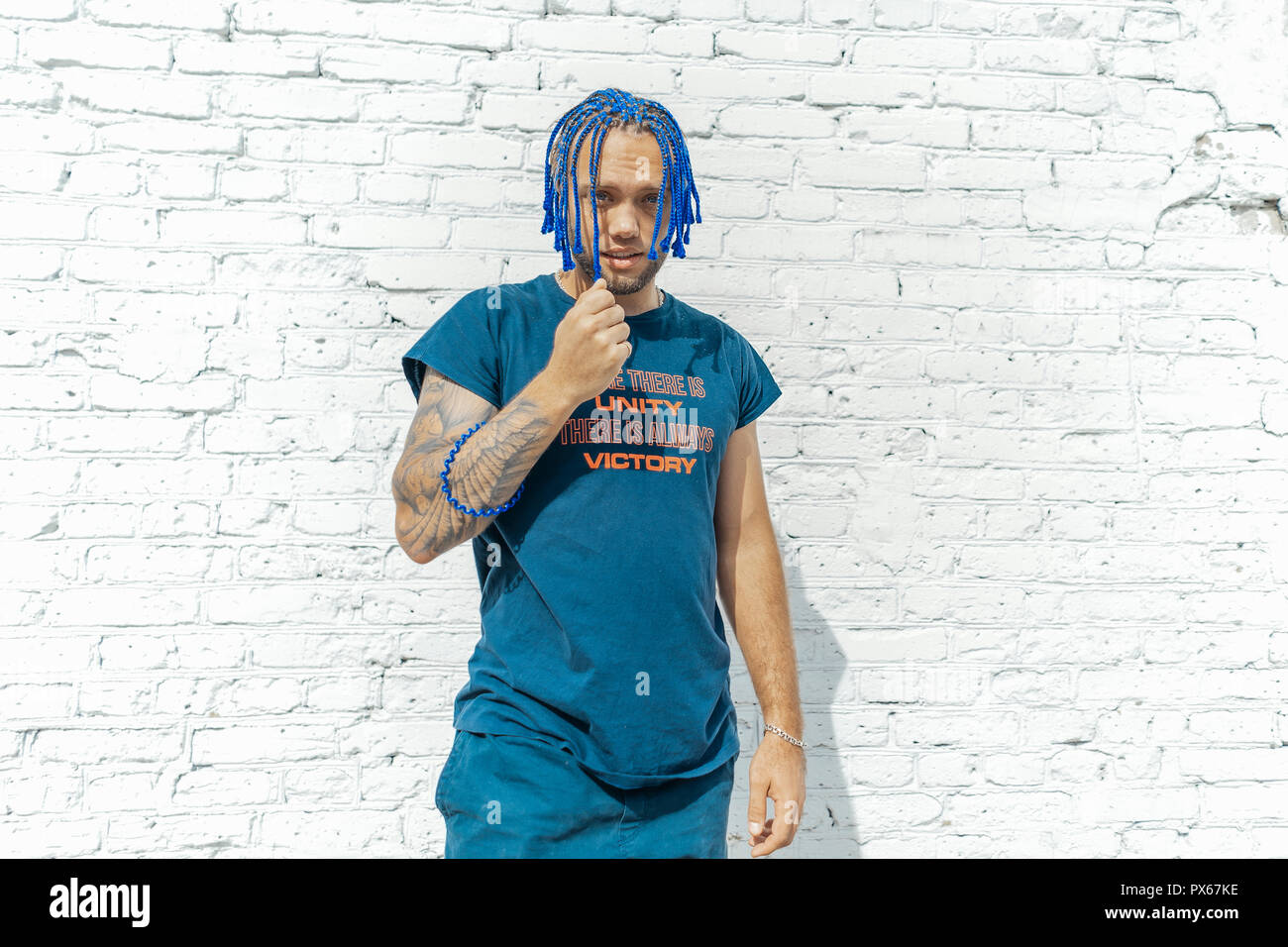 Young Attractive Man With Blue Dreadlocks Touching His Hair