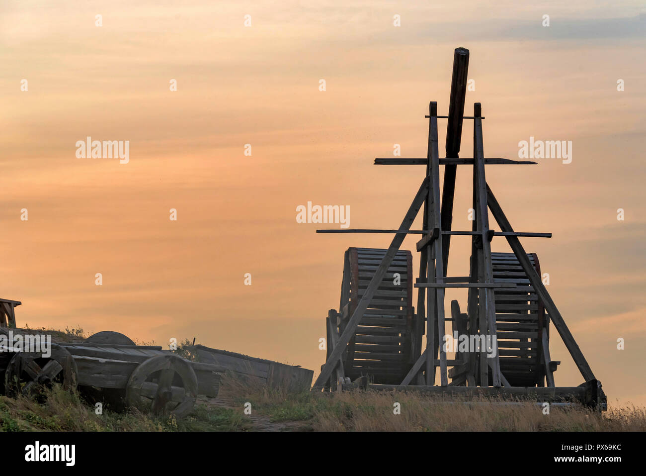 Old wooden catapult against sunset sky background Stock Photo