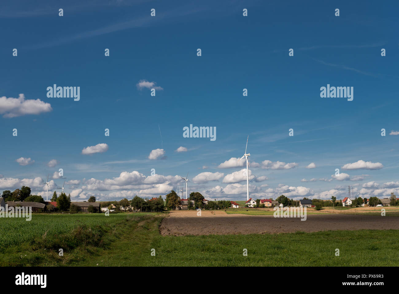 rural landscape with houses and wind turbines over clear blue sky Stock ...