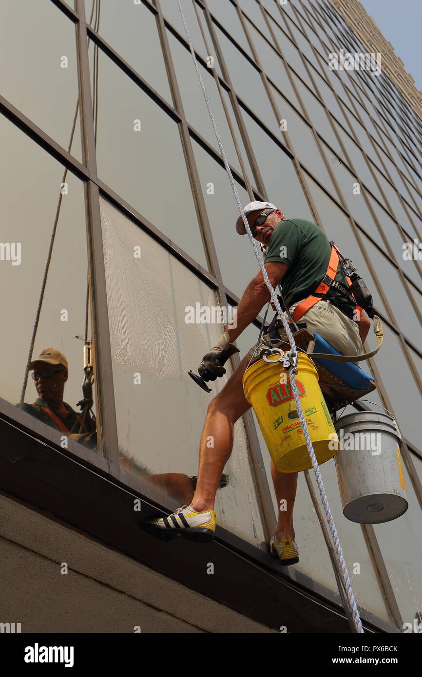 Professional window cleaner suspended in air. Toronto, Ontario, Canada. Stock Photo