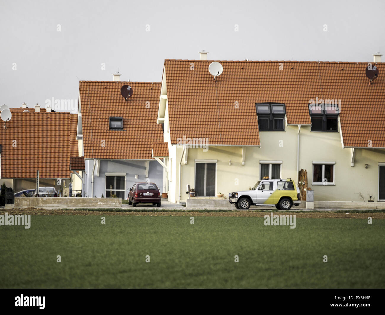 Newly built houses in the country with a row of parked cars, Austria, Lower Austria, Vienna area