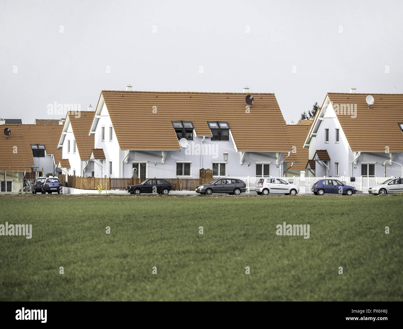 Newly built houses in the country with a row of parked cars, Austria, Lower Austria, Vienna area