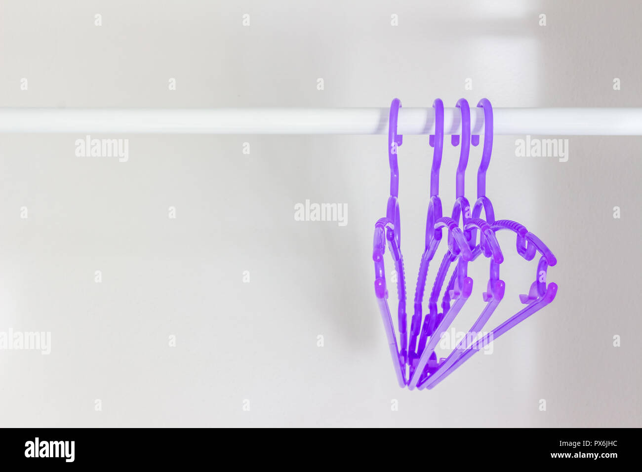 Clothes hangers made of plastic hang on the rail Stock Photo Alamy
