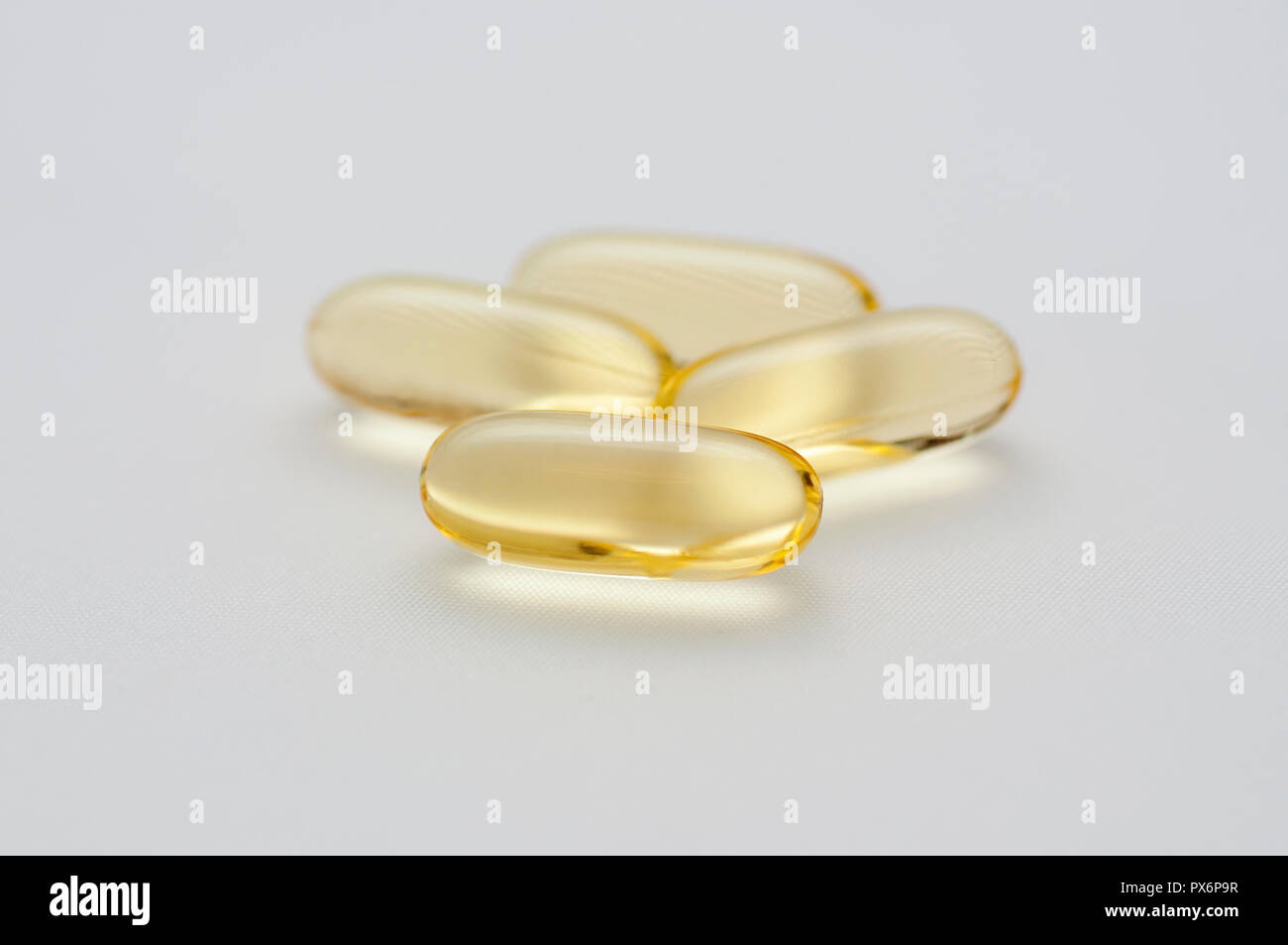 Four gelatine capsules of omega 3 fish oil on white background Stock Photo