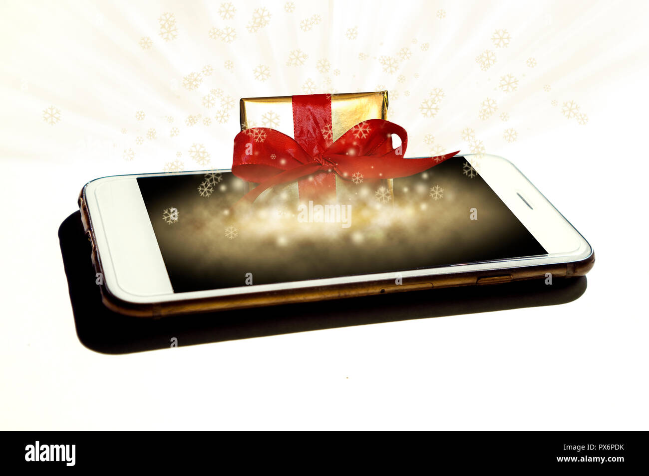 Gold present box magically coming out from the isolated smartphone - Concept of e-commerce sales, online shopping, digital marketing at christmas time Stock Photo