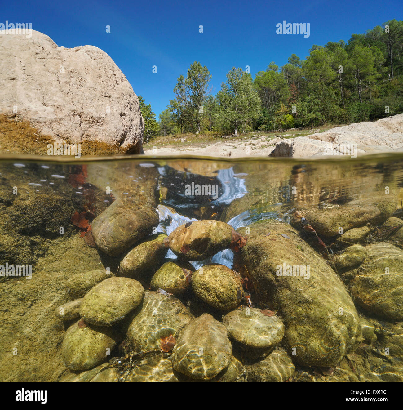 Rocky river, split view half over and under water, La Muga, Alt Emporda, Catalonia, Spain Stock Photo