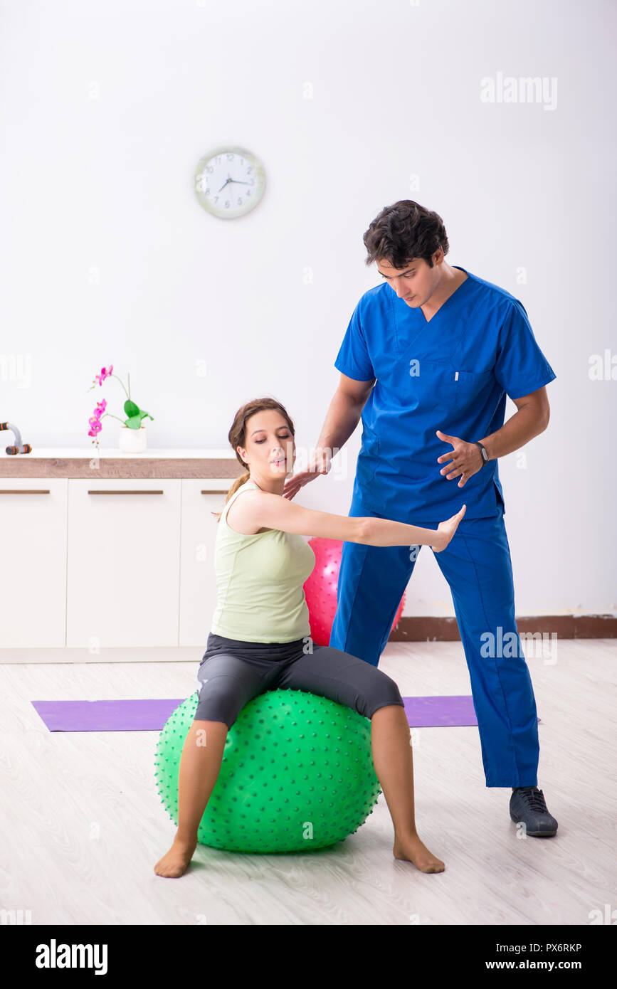 Fitness instructor helping sportsman during exercise Stock Photo - Alamy