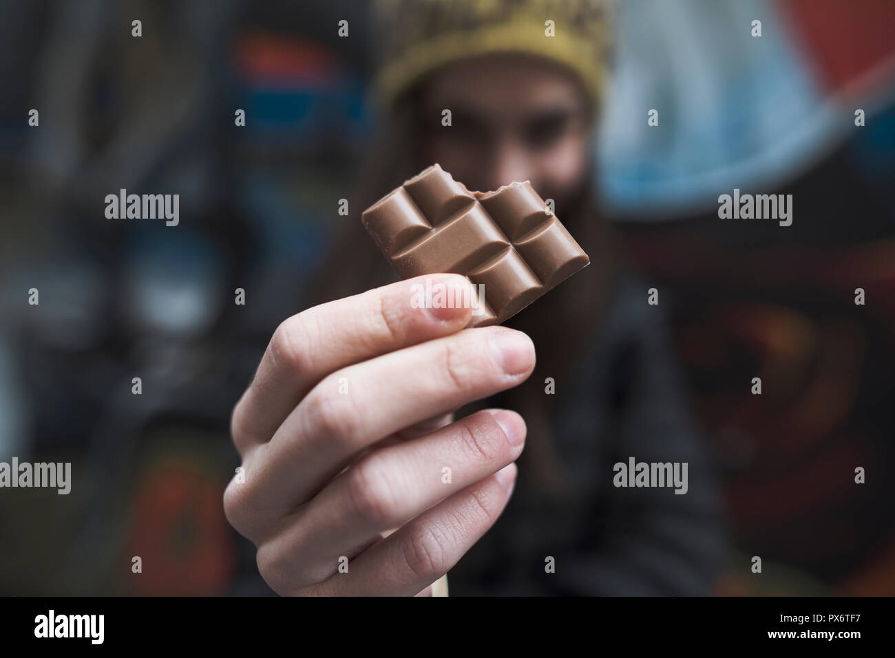 close up on a woman's hands holding a bitten piece of chocolate bar Stock Photo